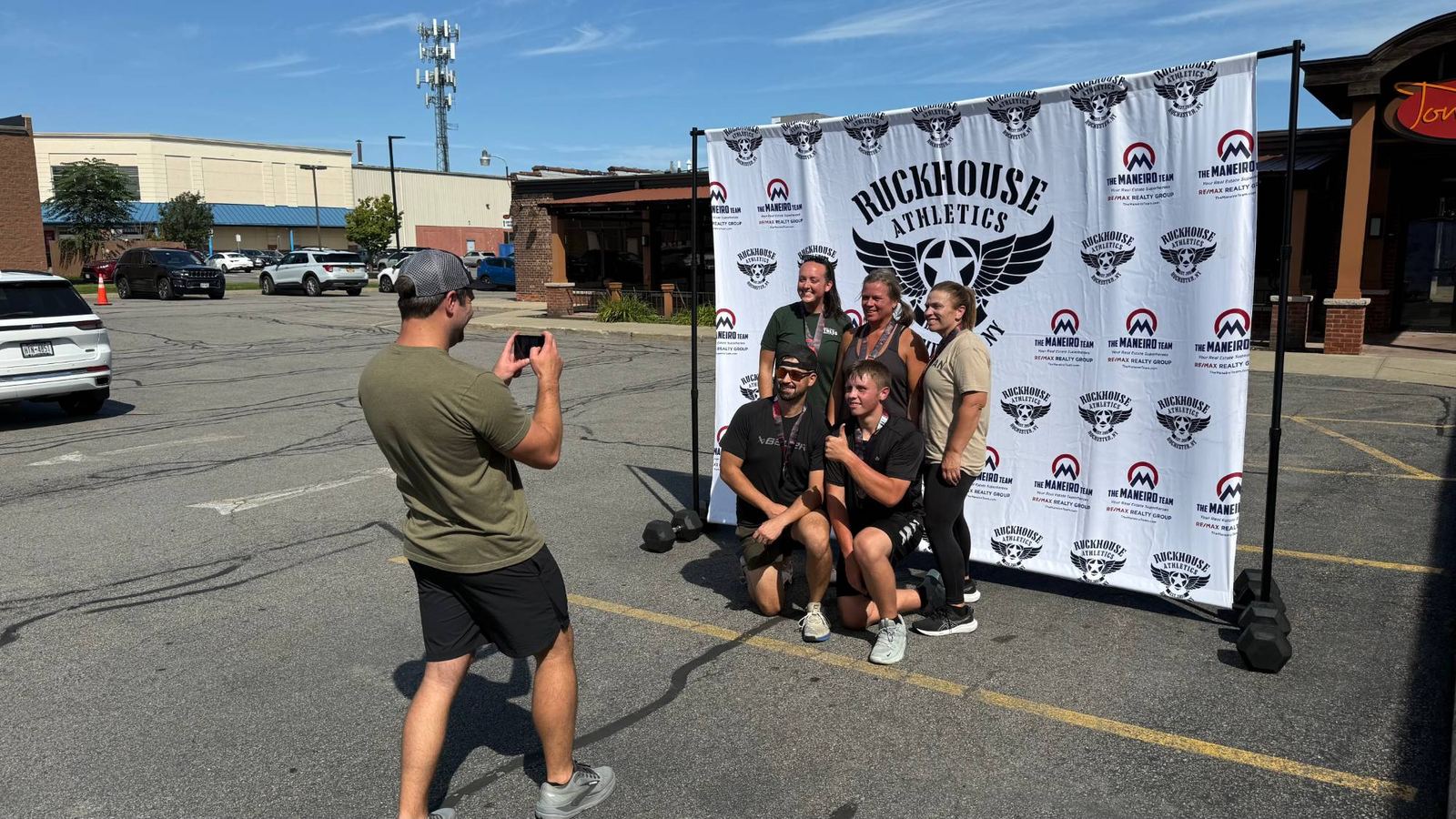 Ruckhouse Athletics members posing with their medals after the DEKA event in the gym parking lot in Rochester NY
