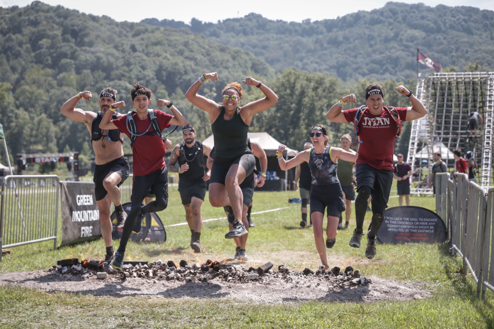 The Ruckhouse Athletics crew flexing as they jump the fire together at the Spartan West Virginia race