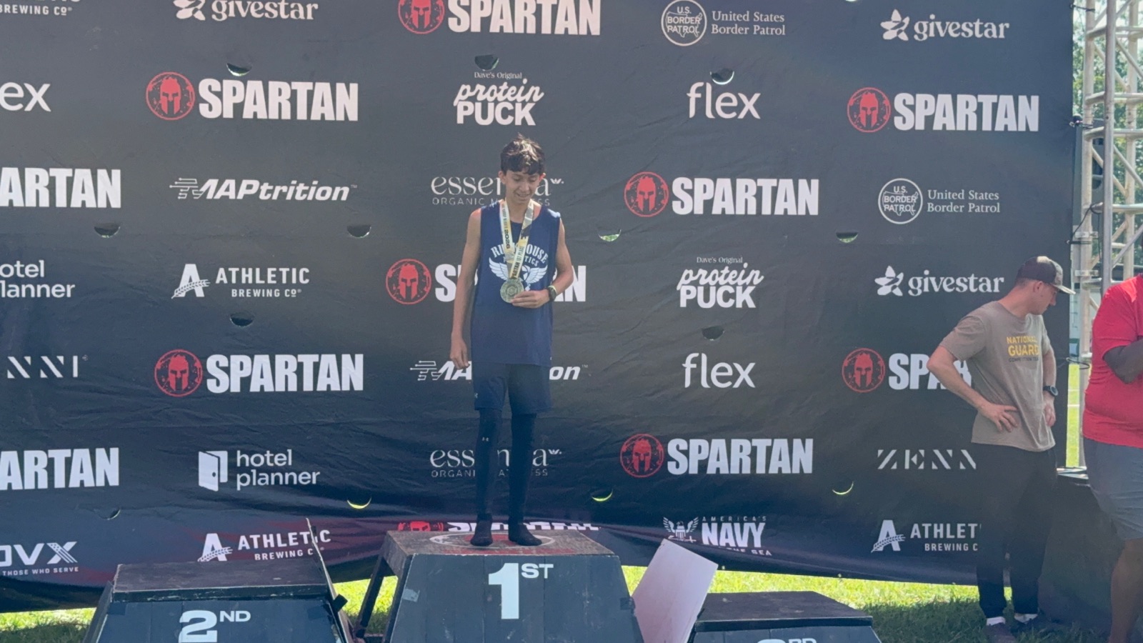 Ruckhouse Athletics athlete standing on the first place podium with his medal at a 2026 Spartan Race